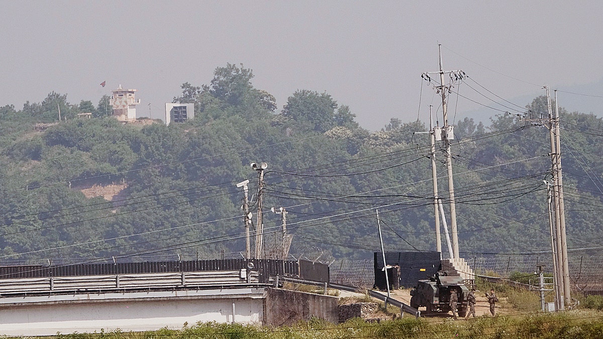 A North Korean military guard post, loudspeaker, top left, and South Korean army soldiers, bottom right, are seen from Paju, South Korea, near the border with North Korea, on June 12.(AP Photo/Ahn Young-joon)
